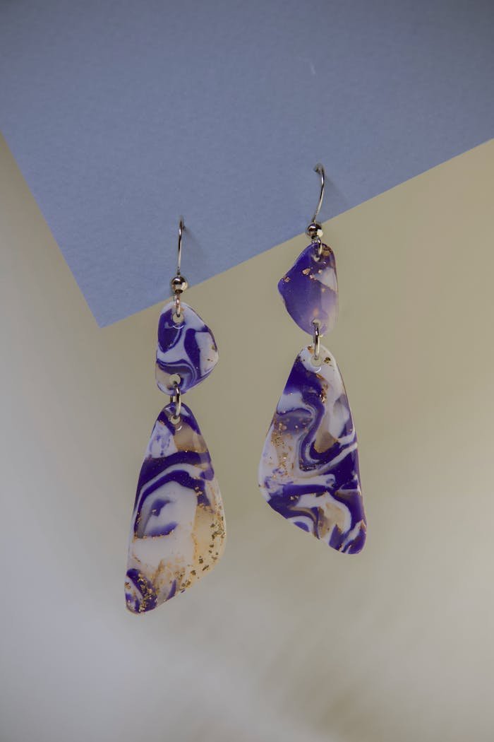 Close-up of unique purple marbled earrings in an artistic and fashion-forward style.